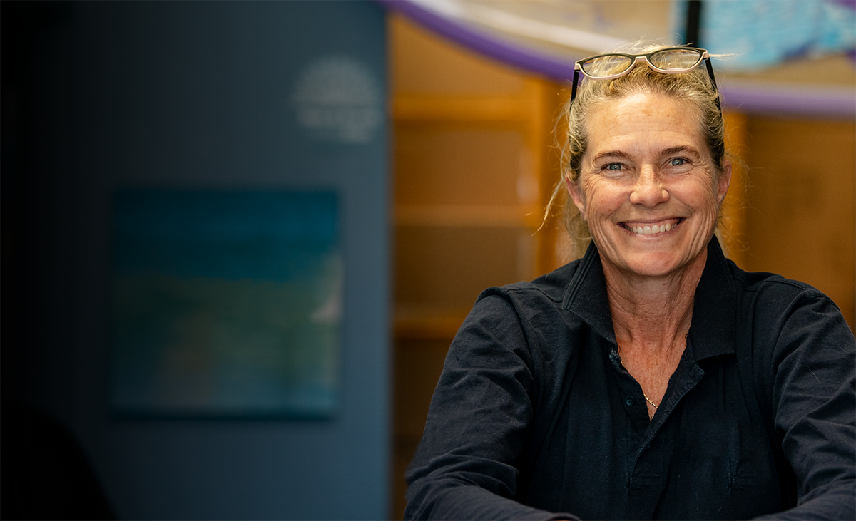 Smiling woman with glasses on her head inside a community space